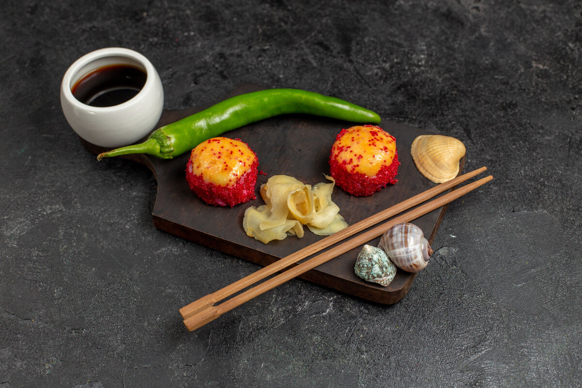 米饭美味的寿司鱼卷的正面图 里面有鱼和米饭 还有青椒和灰墙上的棍子美味棍子面包卷