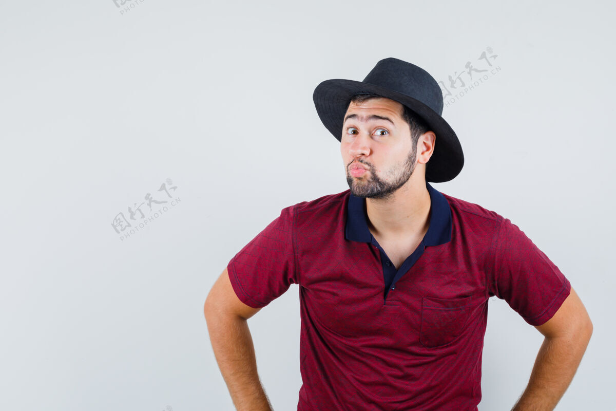 撅嘴年轻男子撅着嘴 穿着t恤 戴着帽子 看上去很怪异 正前方视图帽子英俊年轻