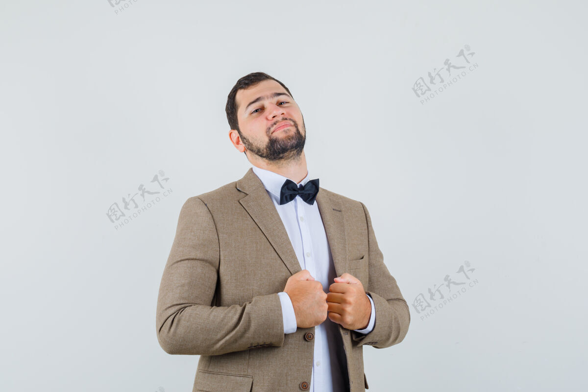 拉风穿西装的年轻男子拉着夹克衫的领子 看上去很自信 前视图成年人人自信