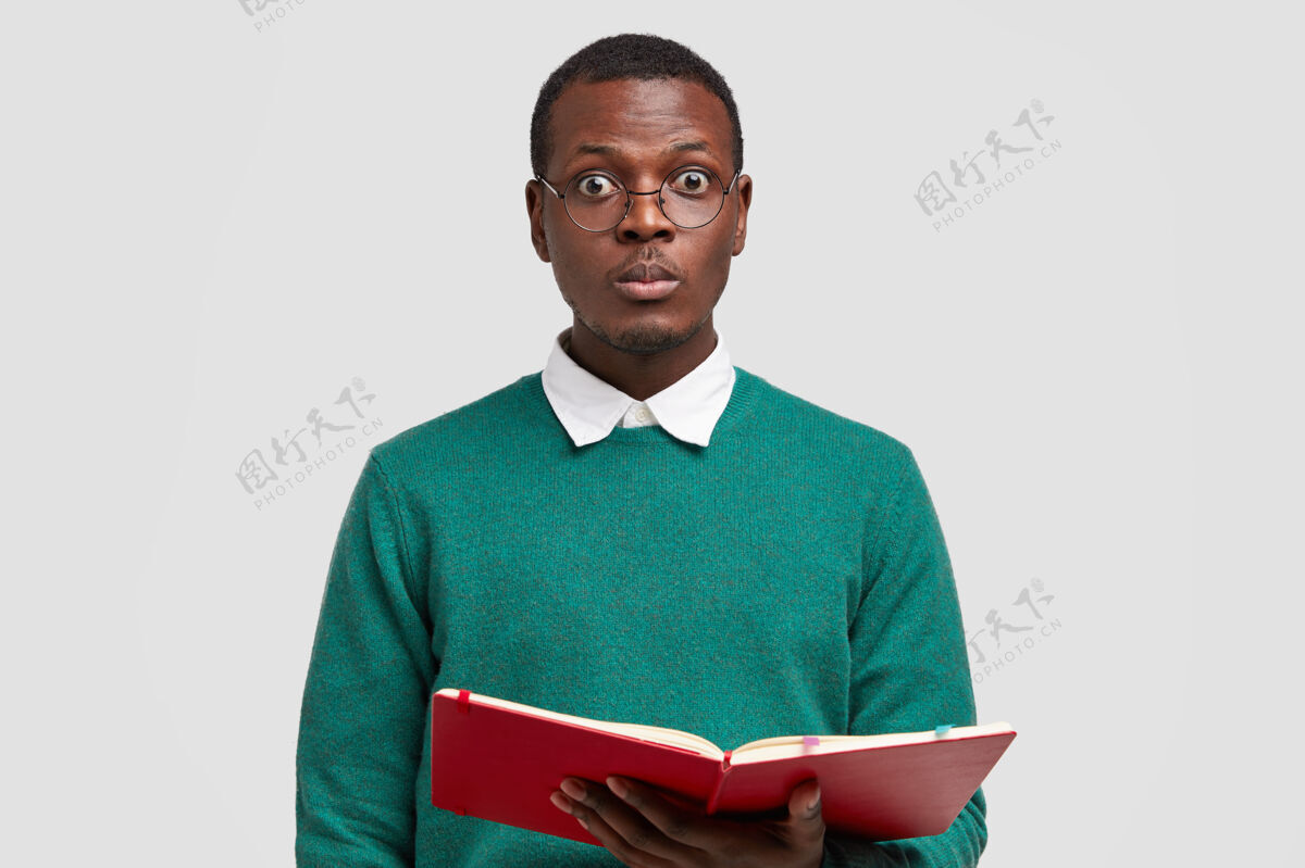 眼镜惊讶的黑人男老师照片直视镜头 戴着眼镜 拿着笔记本 主持讲座男孩阅读眼镜