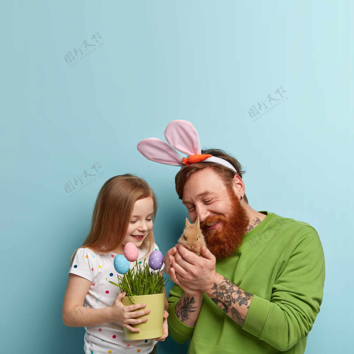 兔子姜黄胡子的男人穿着五颜六色的衣服 他的女儿抱着兔子肖像女儿人